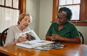 Care giver and aging adult read a book together