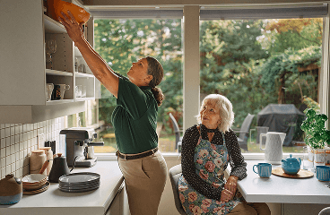 Care giver reaches for a top shelf